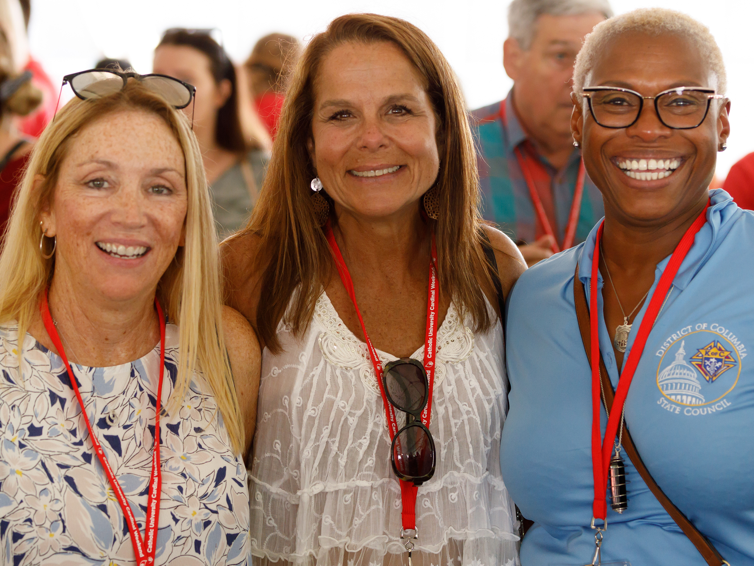 Three alumnae smile during the Pre-Game Tent Party