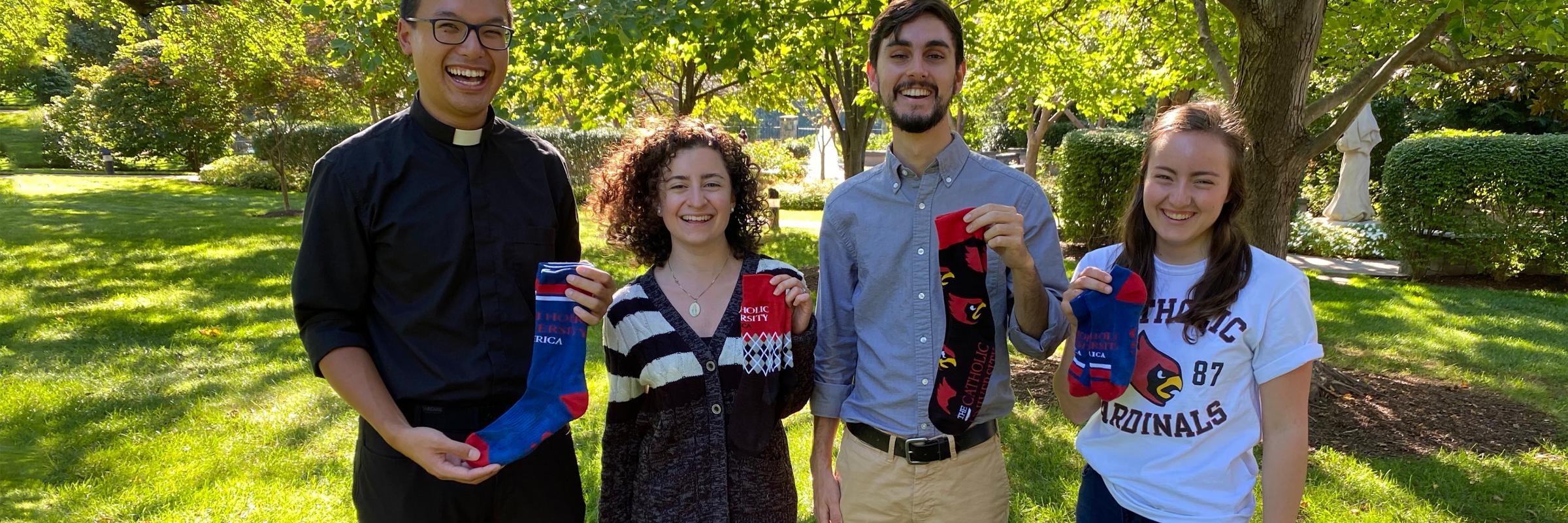 Students hold one of each sock and smile