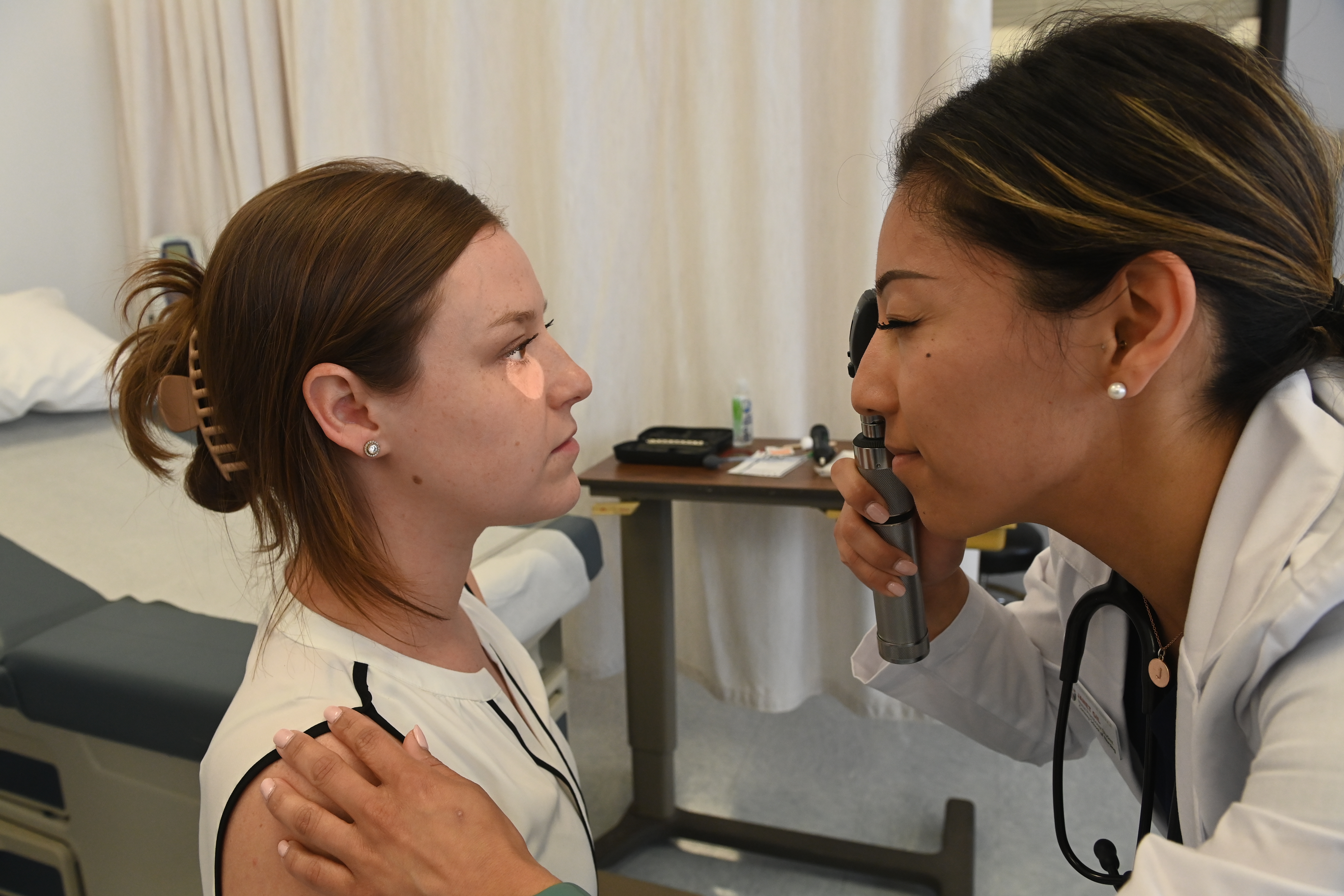 Nursing student checking a patient's eye
