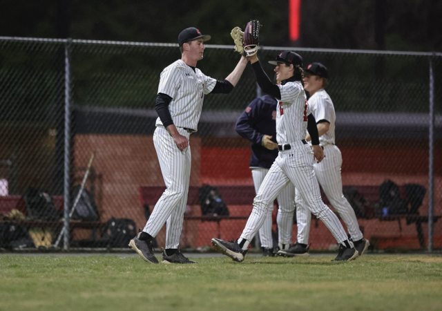 CatholicU baseball players give each other a high five