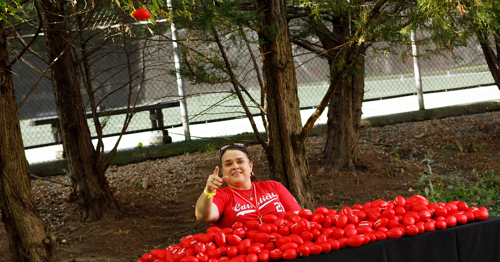Woman in a CatholicU shirt throws a stress reliever football