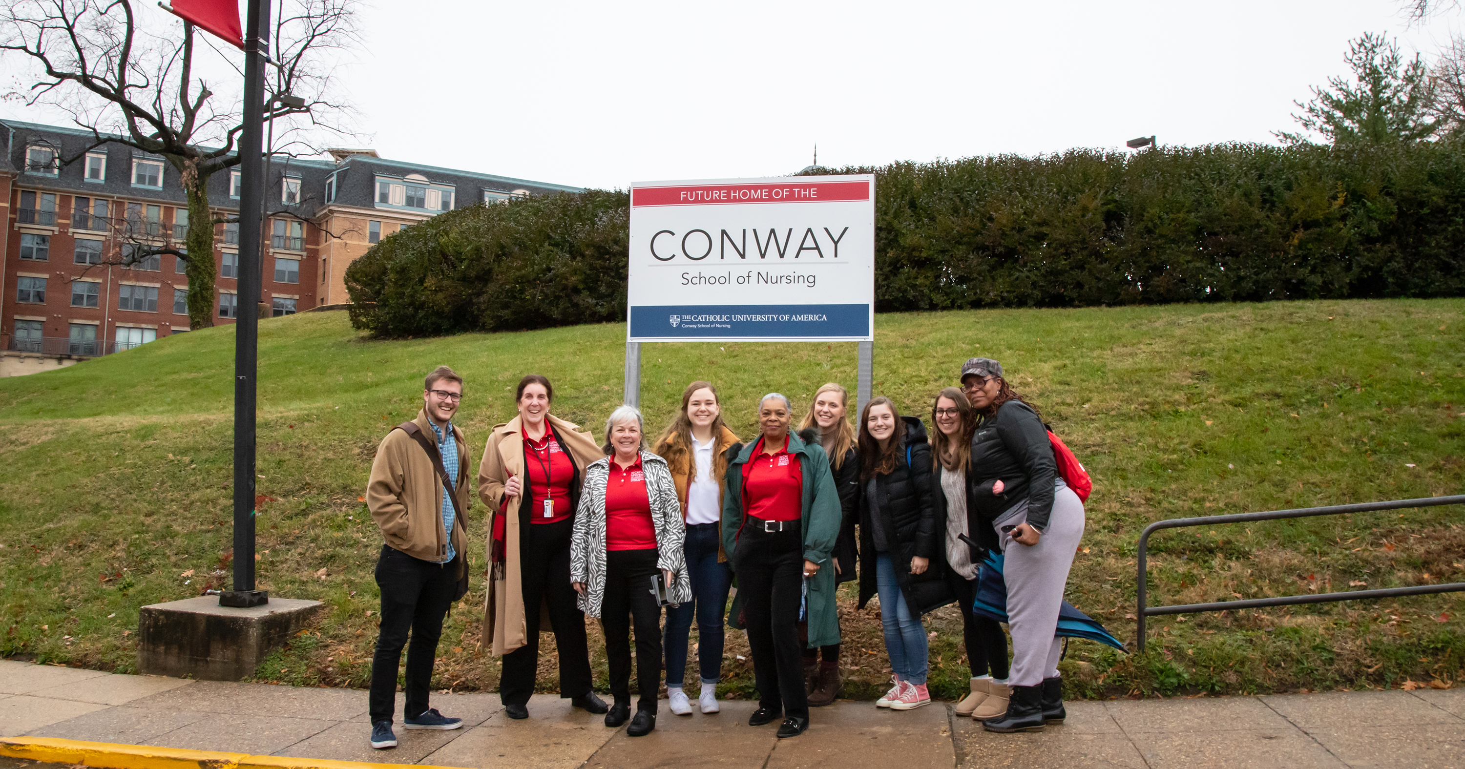 Students and faculty pose by the future site of the Nursing and Sciences building