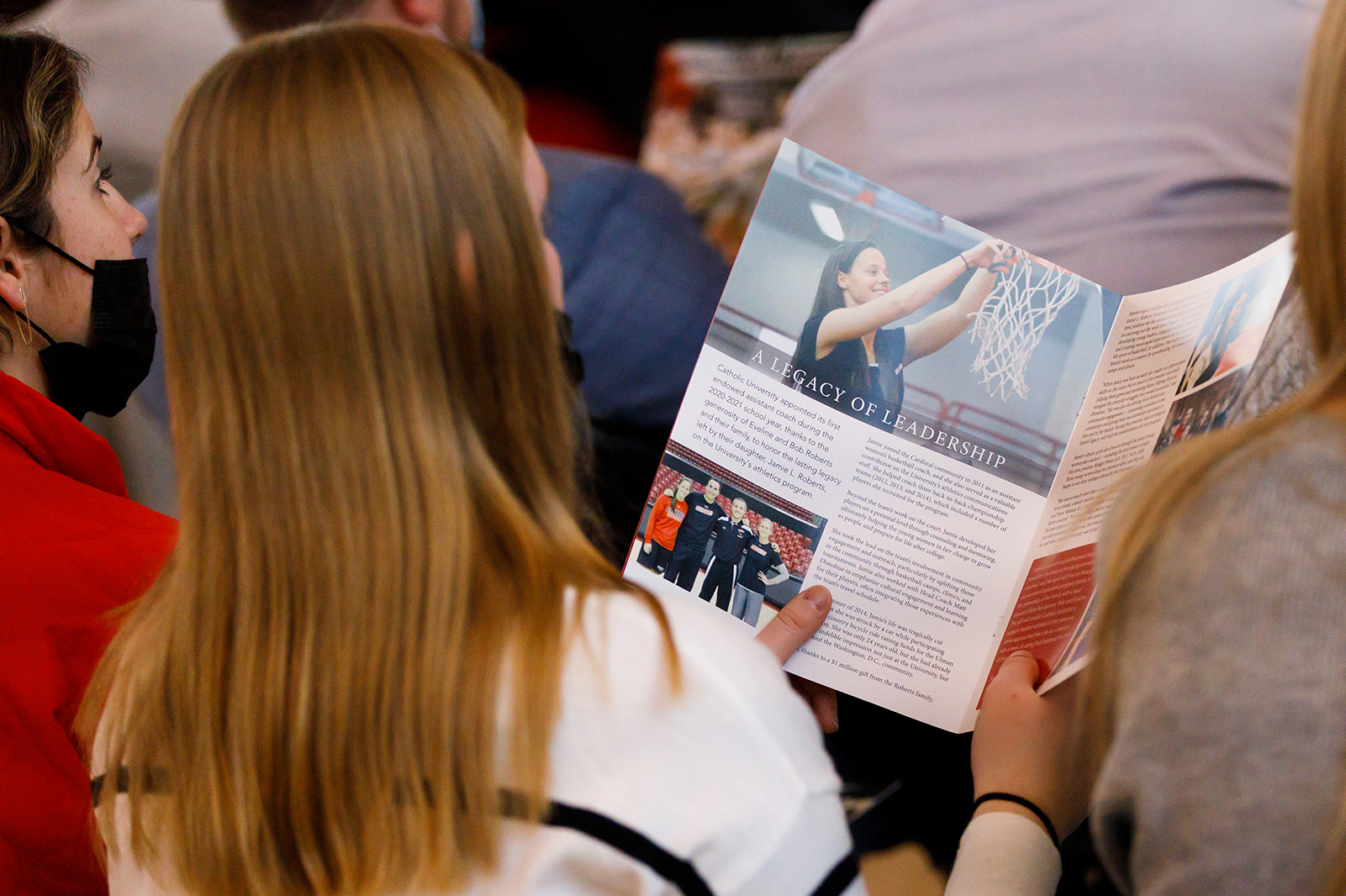 An audience member reads about Jamie in the program book
