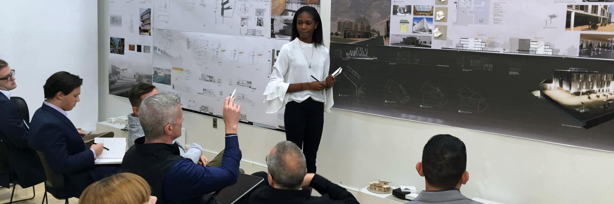 An architecture student presents to seated adults