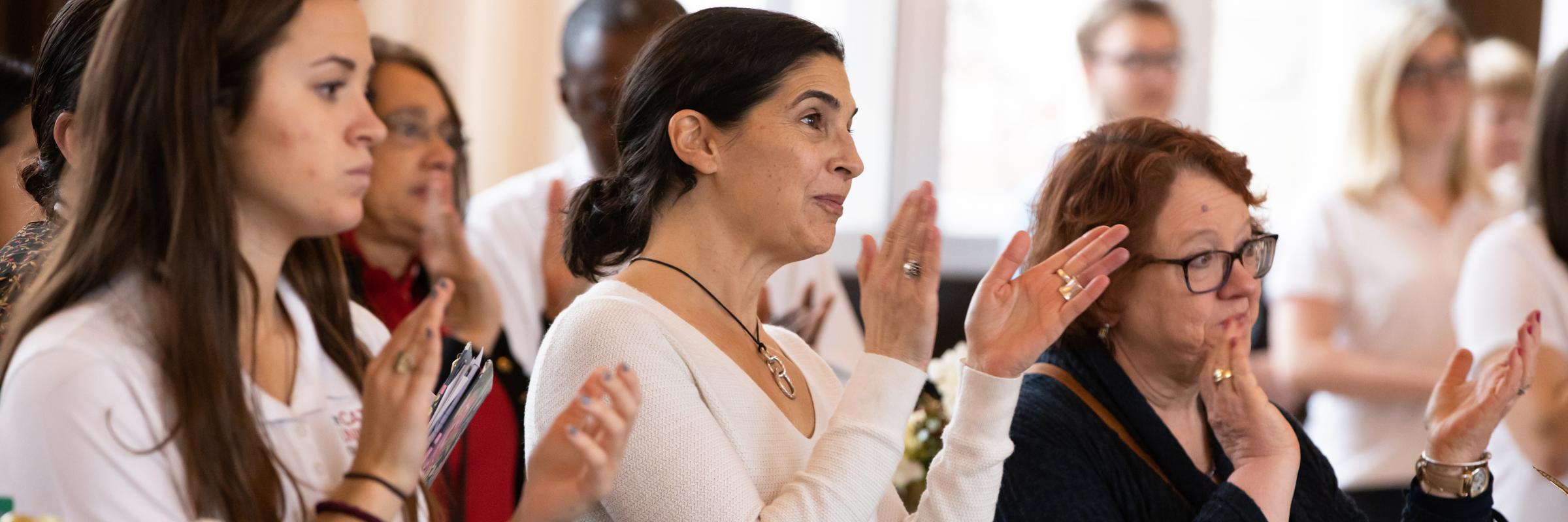 Three women applaud
