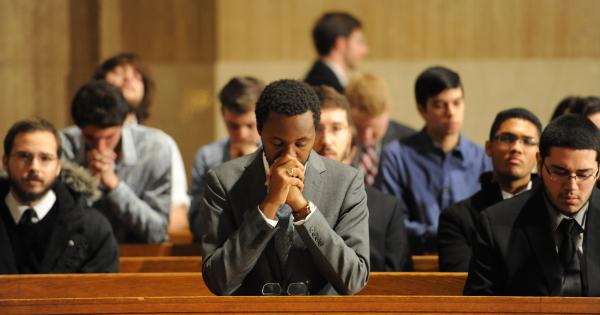 A student praying in a chapel with other students