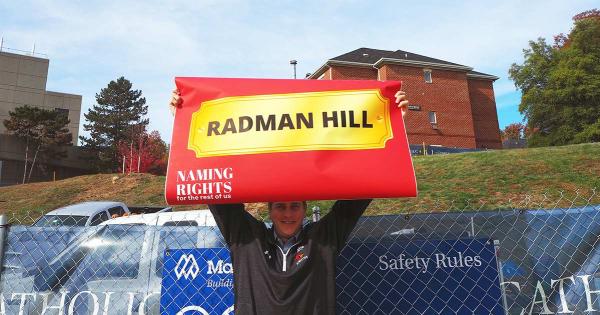 Patrick Dwyer holds a Radman Hill sign