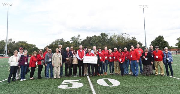 Reunion alumni present a large check on the football field