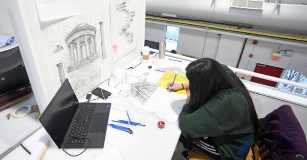 Architecture student drawing in work space
