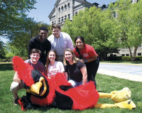 Students posing with the CatholicU mascot, Red