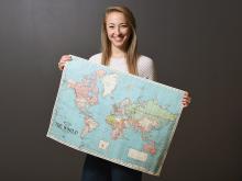 Scholarship student holding a world map